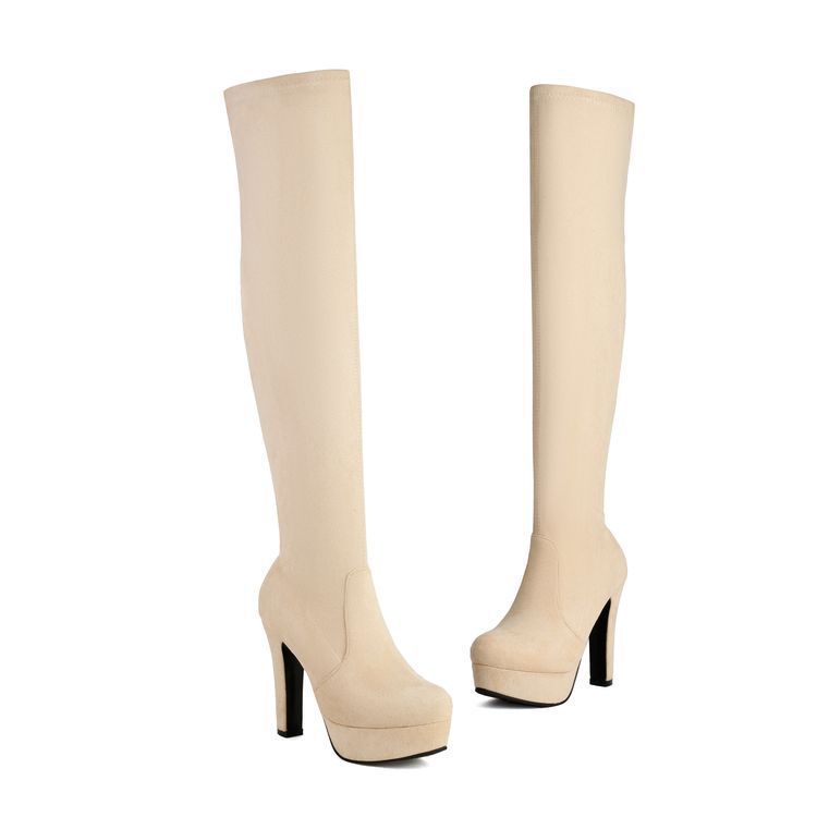 Beige knee-high boots with black platform soles on a white background