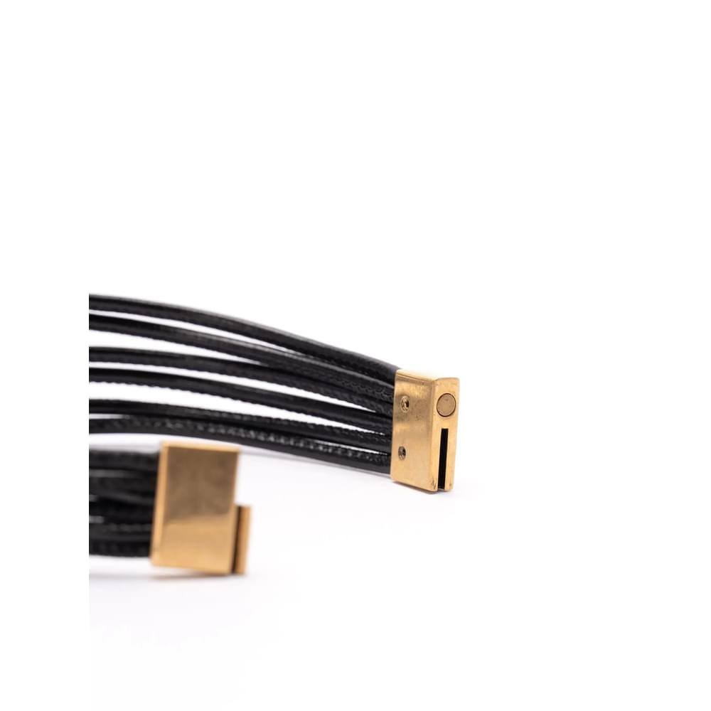Black leather strap with gold hardware on a white background Saint Laurent Gold Bracelets Women