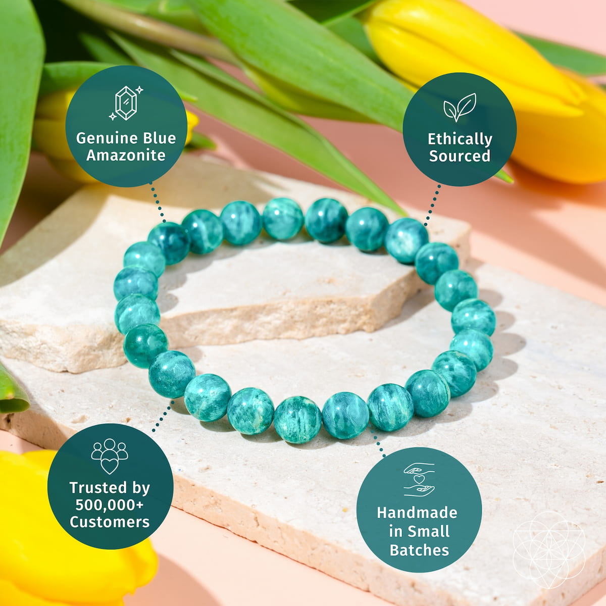 Turquoise beaded bracelet on a stone surface with green leaves and yellow flowers in the background. Empire of Her Own – Premium Blue Amazonite Bracelet