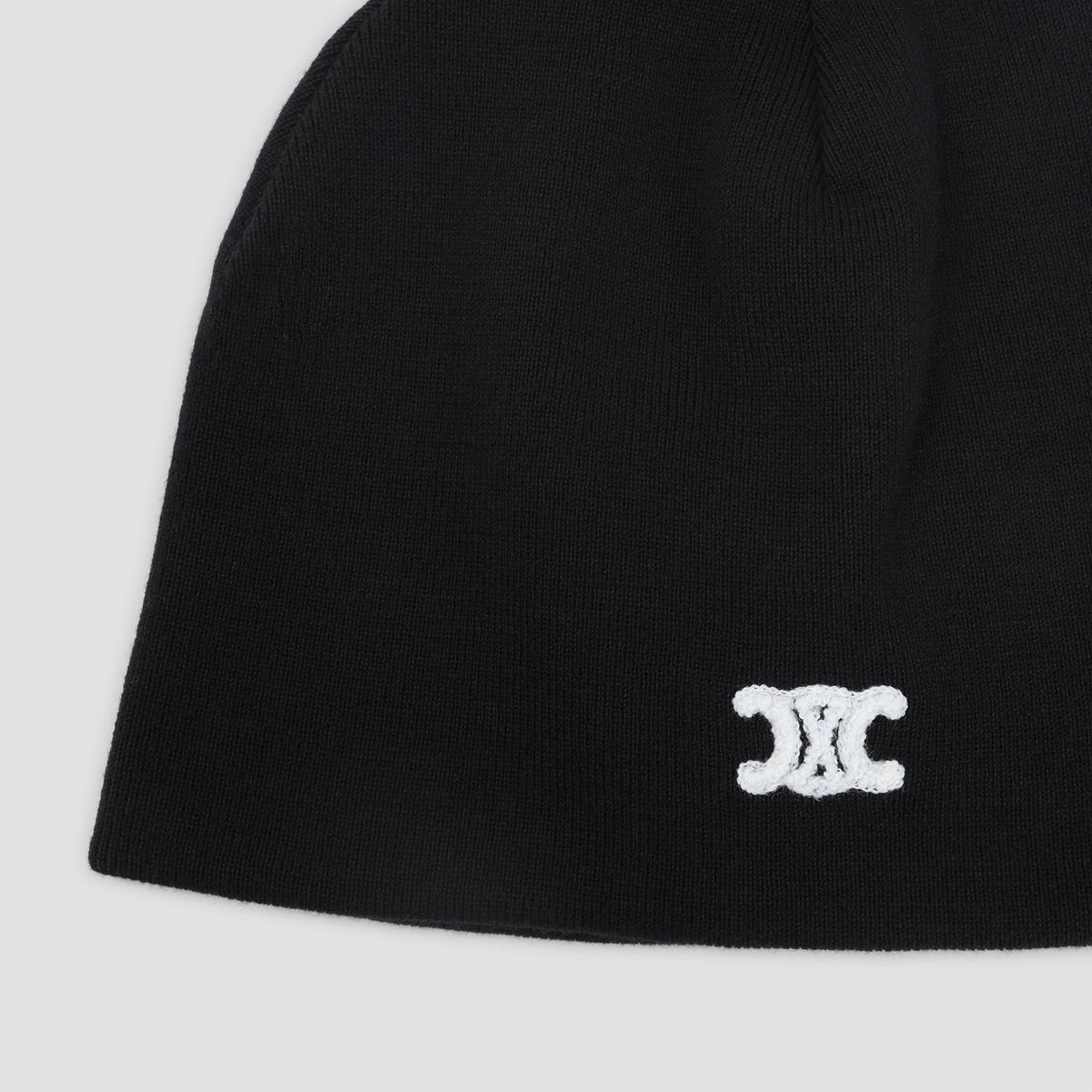 Black beanie with a white logo on a light gray background