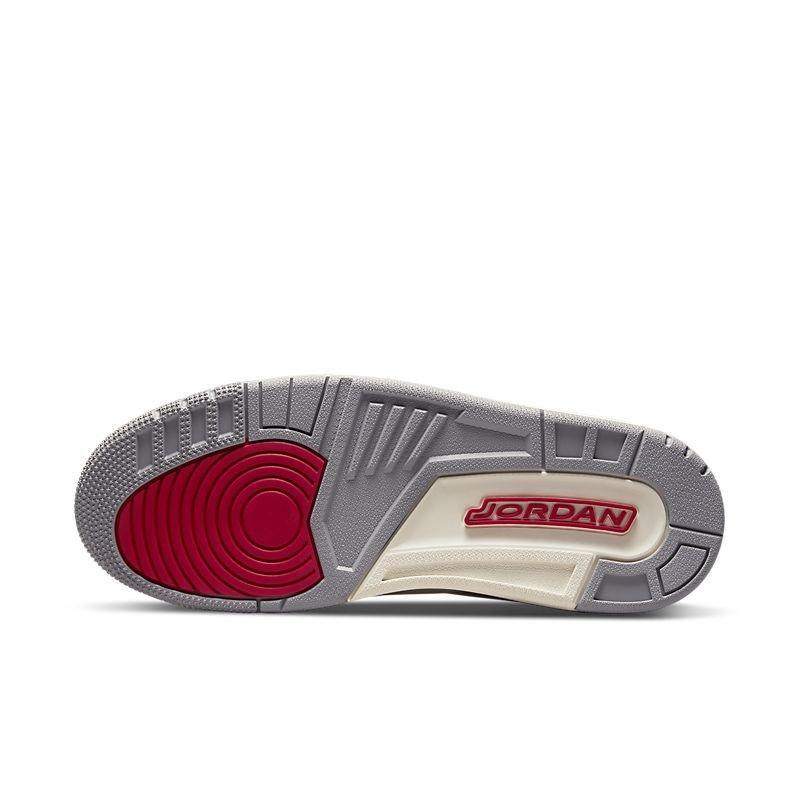 Close-up of a Jordan Air Jordan 3 Retro 'Muslin' sneaker sole with red and gray design on a white background