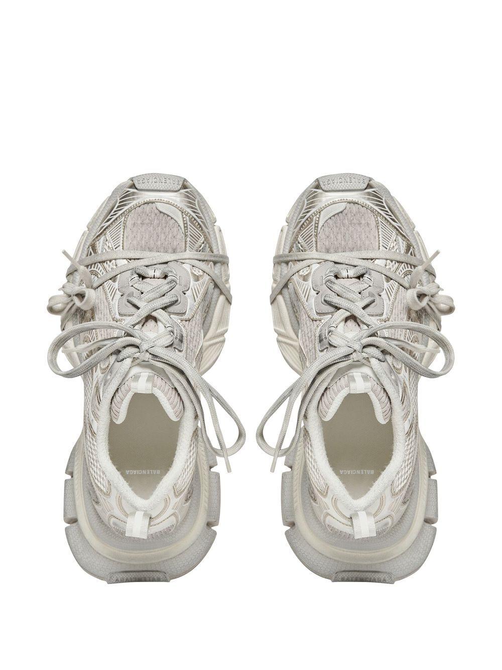 A pair of chunky, multi-layered platform sneakers in a light gray and off-white colorway, shown from a top-down view on a solid white background.