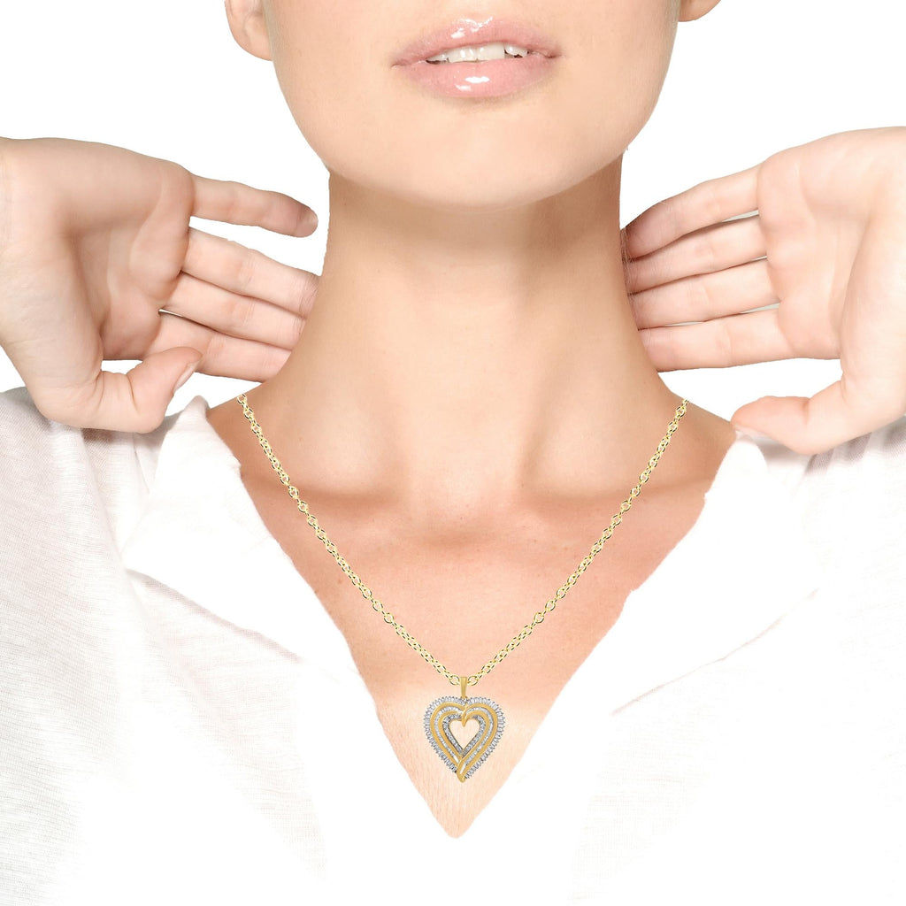 Gold necklace with a heart-shaped pendant worn by a person on a white background