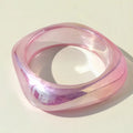 Pink and clear bangle on a light beige background