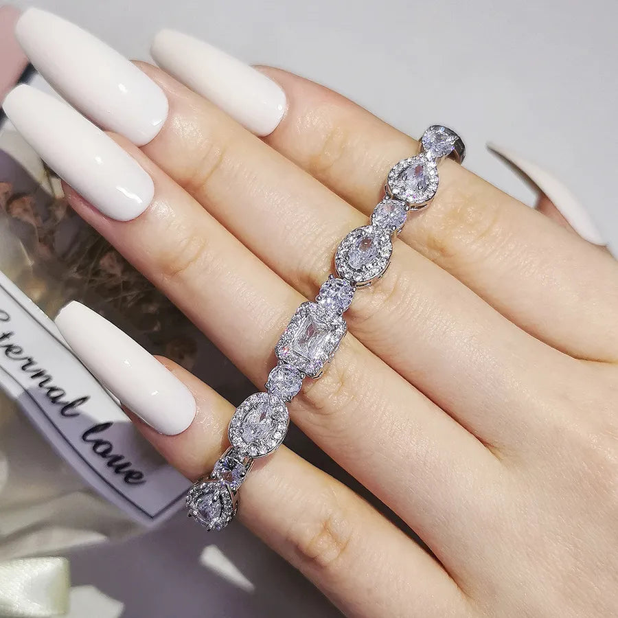 Hand wearing a diamond bracelet with a blurred background