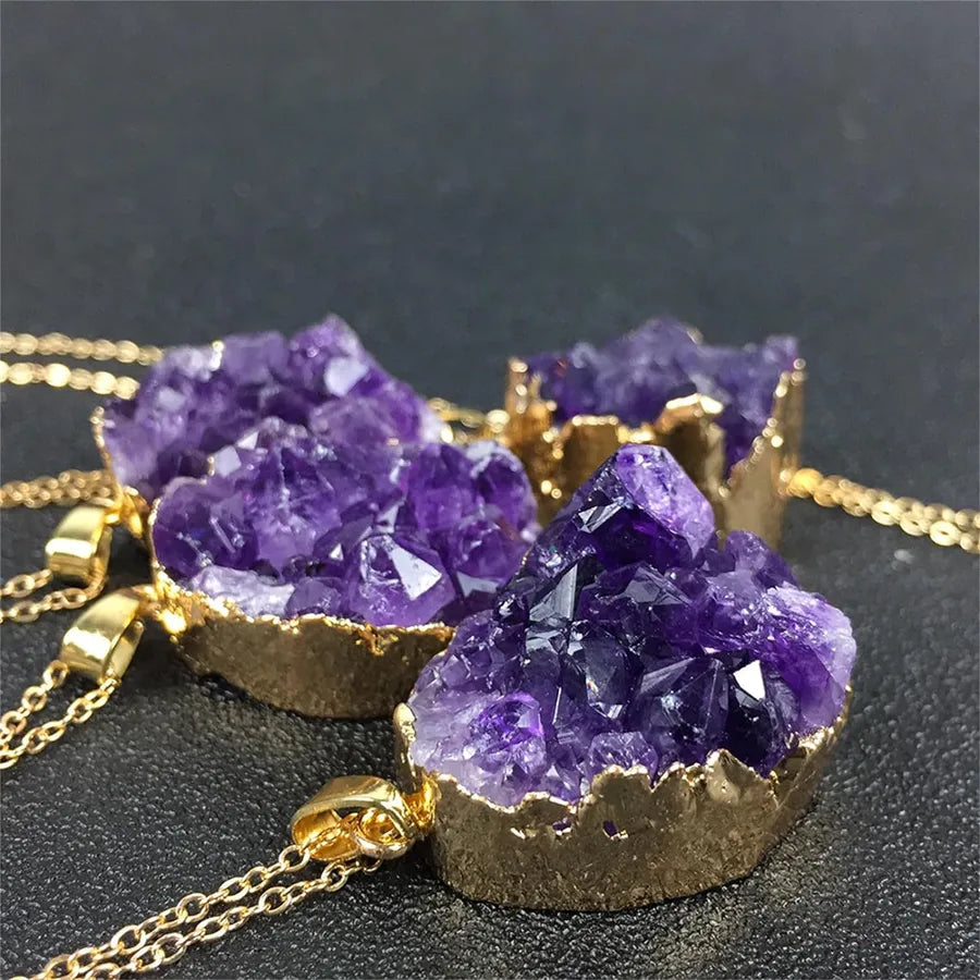 Purple crystal necklaces with gold bases on a dark background