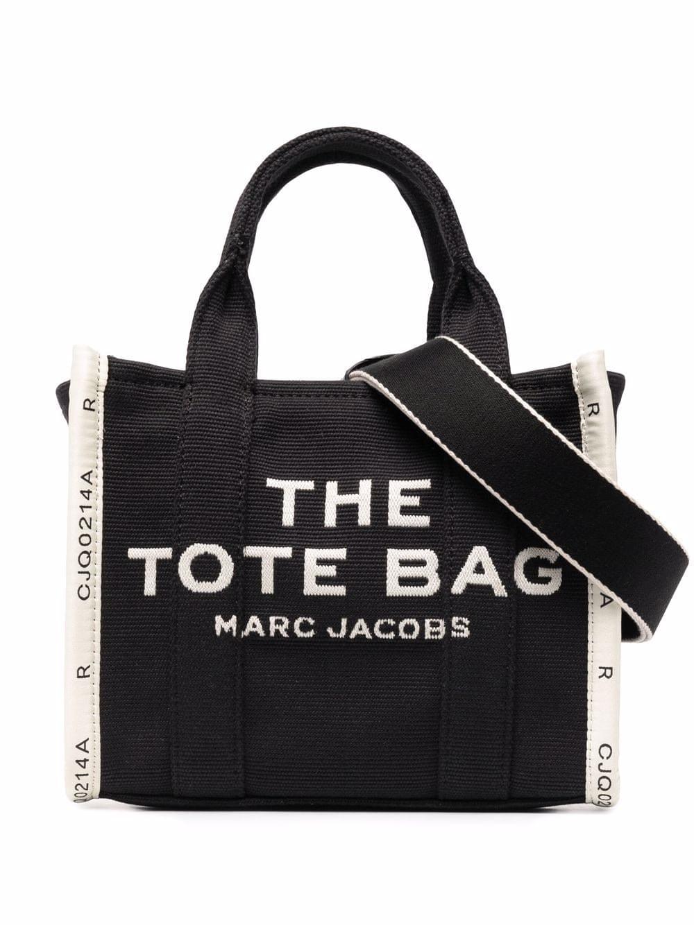 Black tote bag with 'The Tote Bag' and 'Marc Jacobs' text on a white background