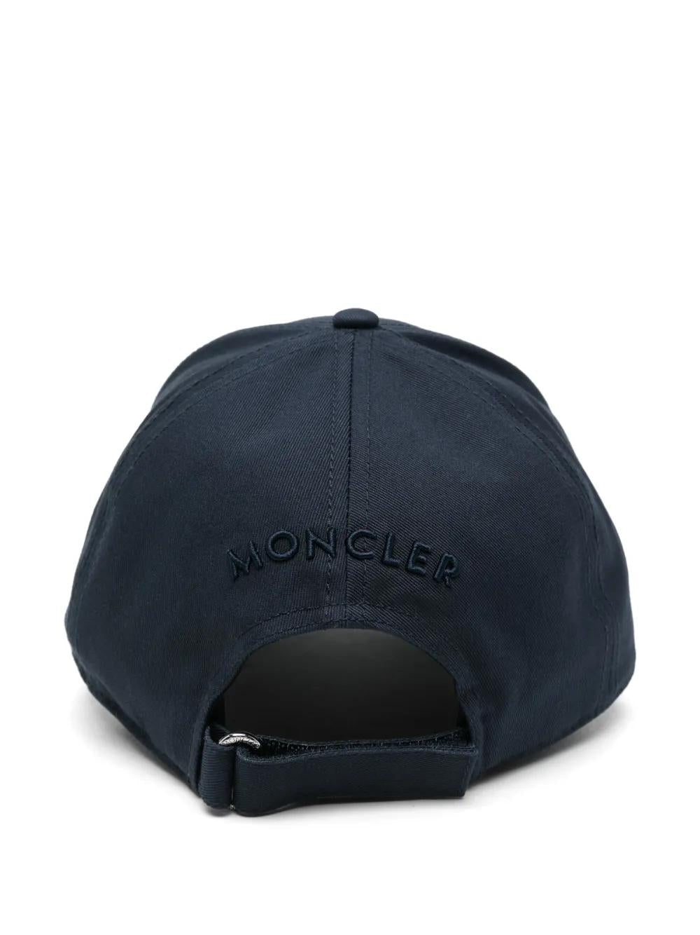 Navy blue cap with 'Moncler' logo on a white background