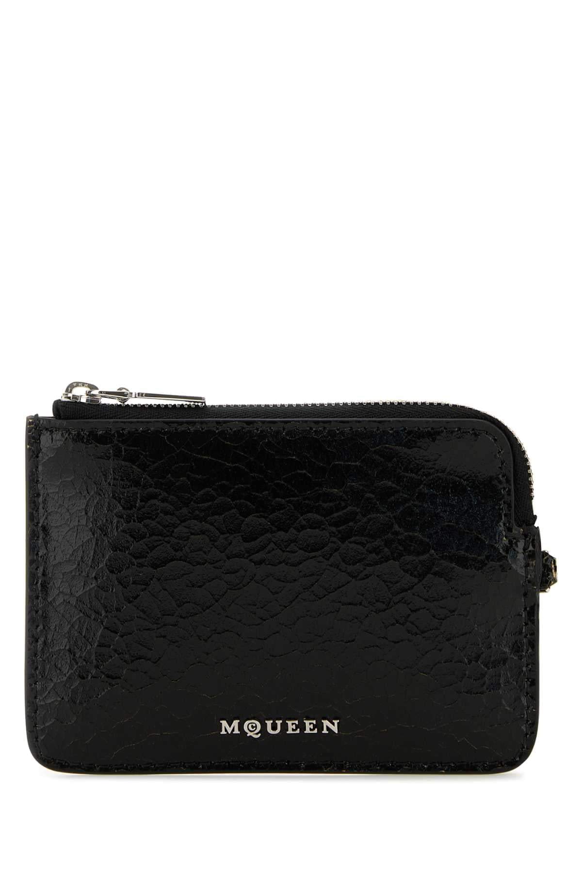 Black textured wallet with 'McQueen' branding on a white background