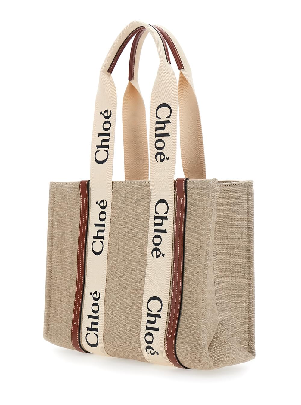 Chloé Woody medium tote bag in beige linen featuring signature logo lettering and brown leather trim.
