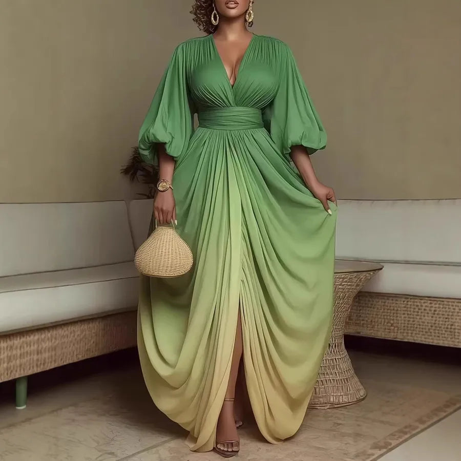 Woman in a green flowing dress holding a woven handbag indoors.