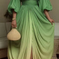 Person wearing a green dress holding a woven handbag indoors.