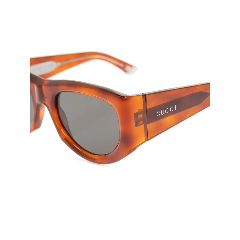 Gucci sunglasses with tortoiseshell frame and dark lenses on a white background