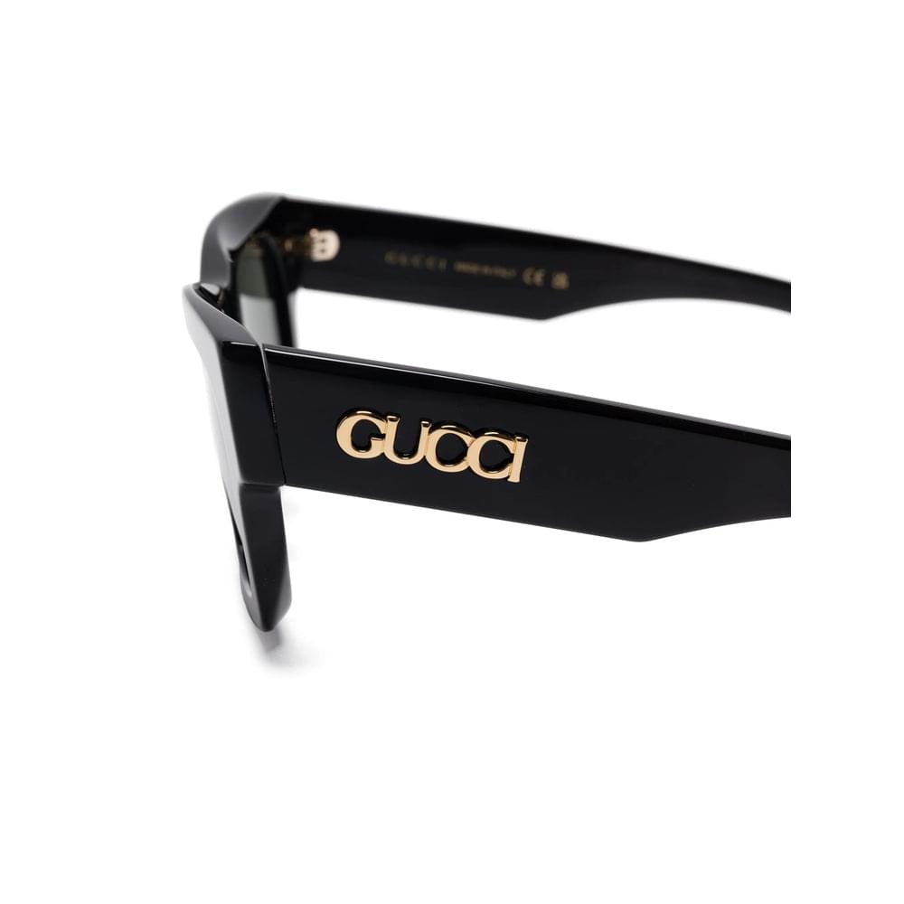 Black Gucci sunglasses with gold logo on a white background