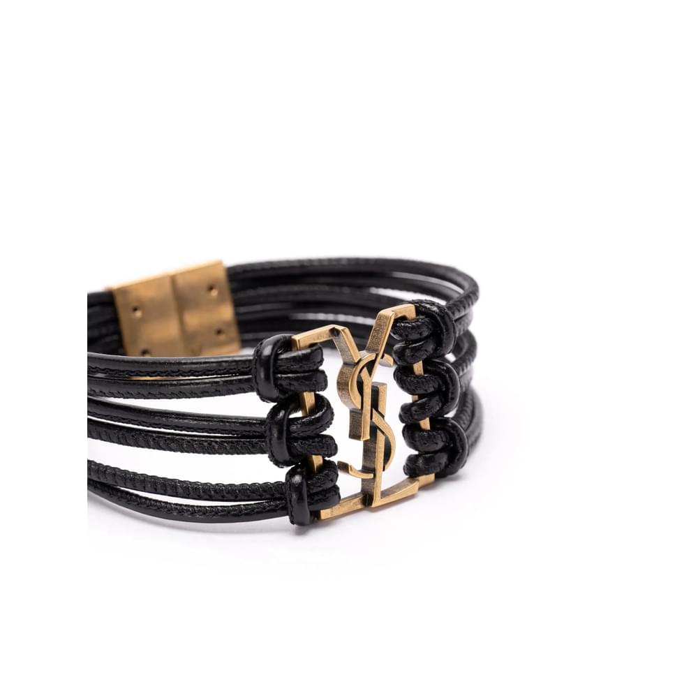 Black leather bracelet with gold clasp on a white background Saint Laurent Gold Bracelets Women