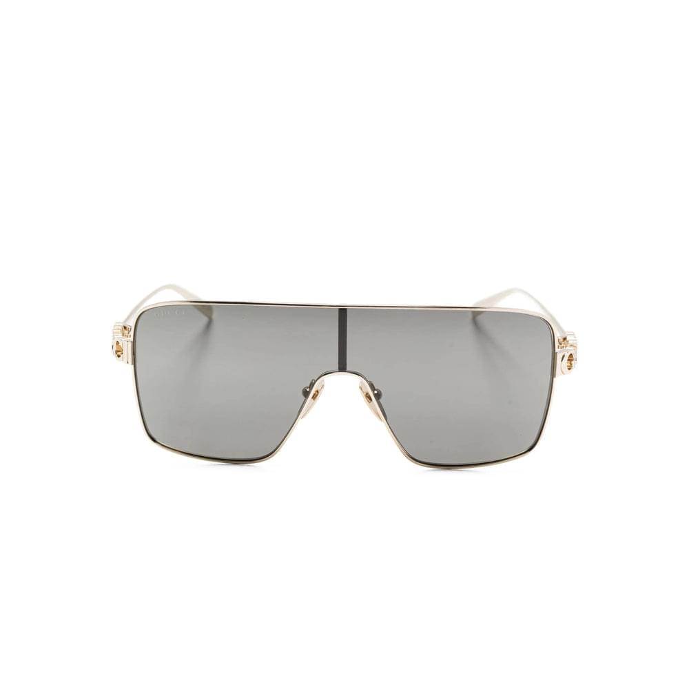 Sunglasses with gold frame and gray lenses on a white background