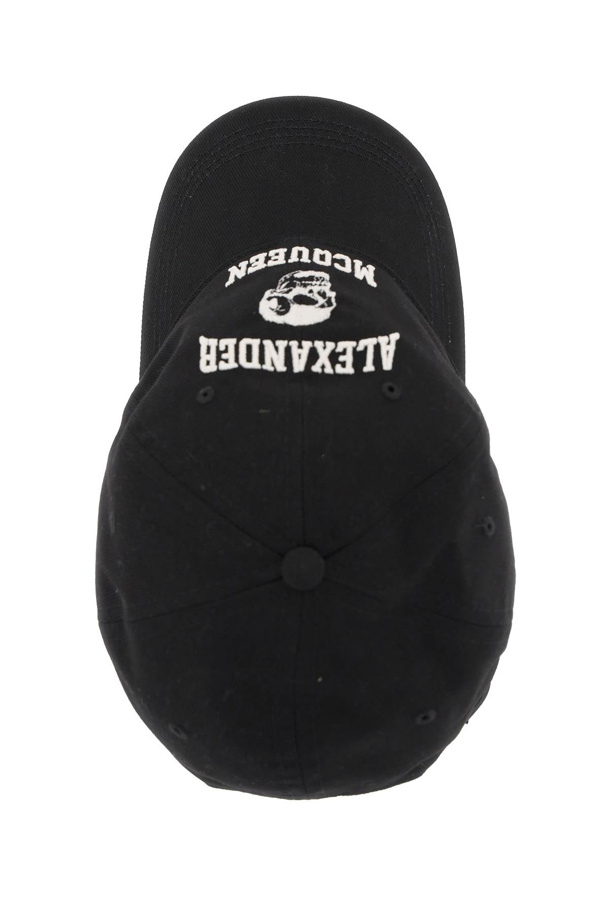 A black baseball cap featuring white embroidered text and a skull graphic on the front, with the text reading 'ALEXANDER' and 'MCGUIREN' upside down.