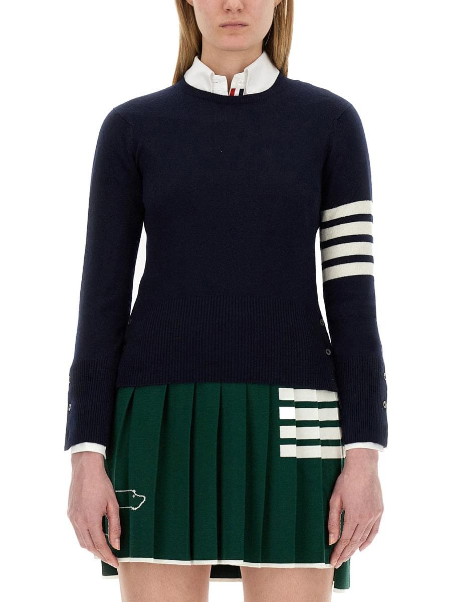 Navy sweater with white and green accents worn by a person on a white background