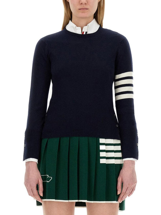 Navy sweater with white and green accents worn by a person on a white background