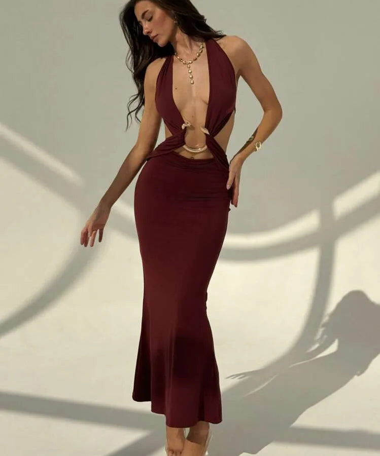 Woman wearing a burgundy dress with cut-out design on a neutral background