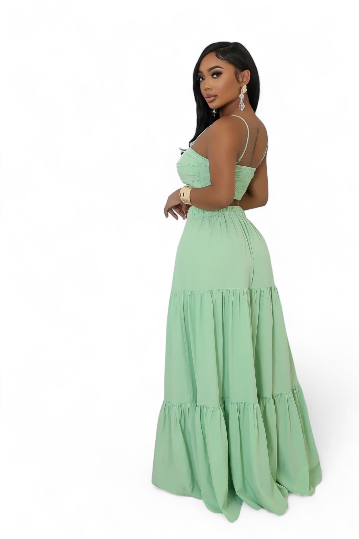 Woman wearing a light green maxi dress on a white background