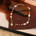Pearl necklace with gold accents on a brown surface