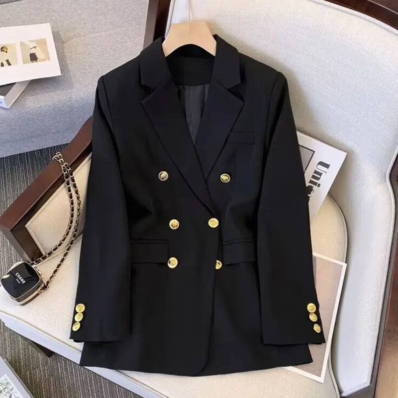Black blazer with gold buttons on a hanger, surrounded by a watch, necklace, and magazine.