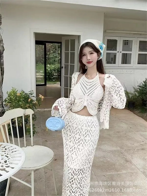 Woman in a white lace outfit standing outdoors near a building.