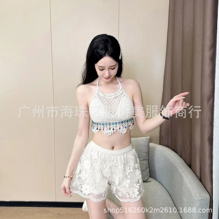 Woman wearing a white lace outfit with a decorative top in a room.