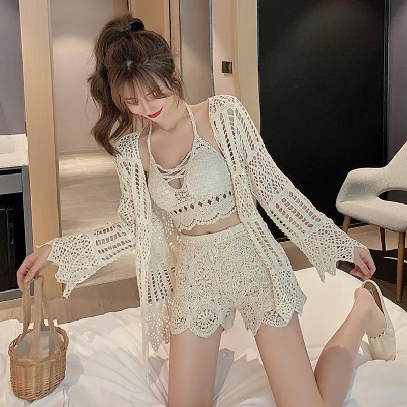 Woman wearing a white crochet outfit in a room.