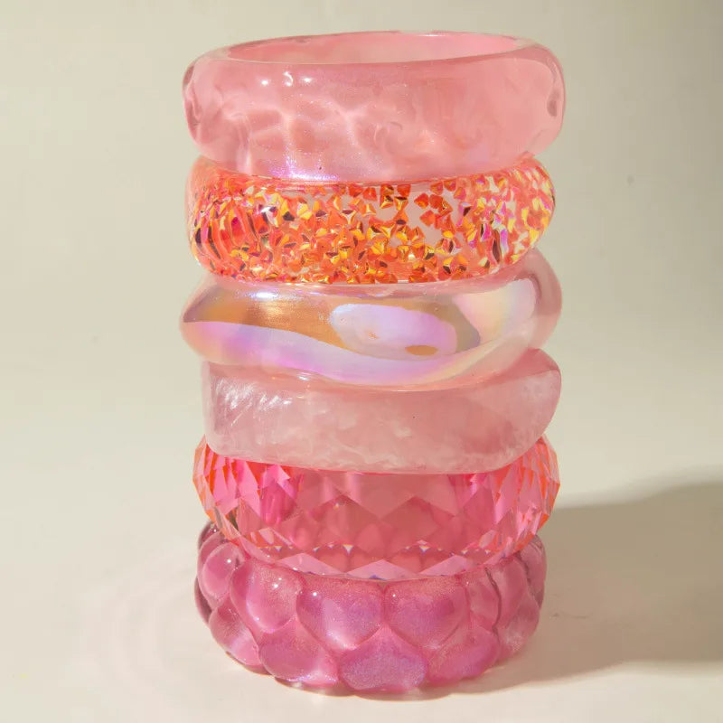 Stack of pink and orange bangles on a light background