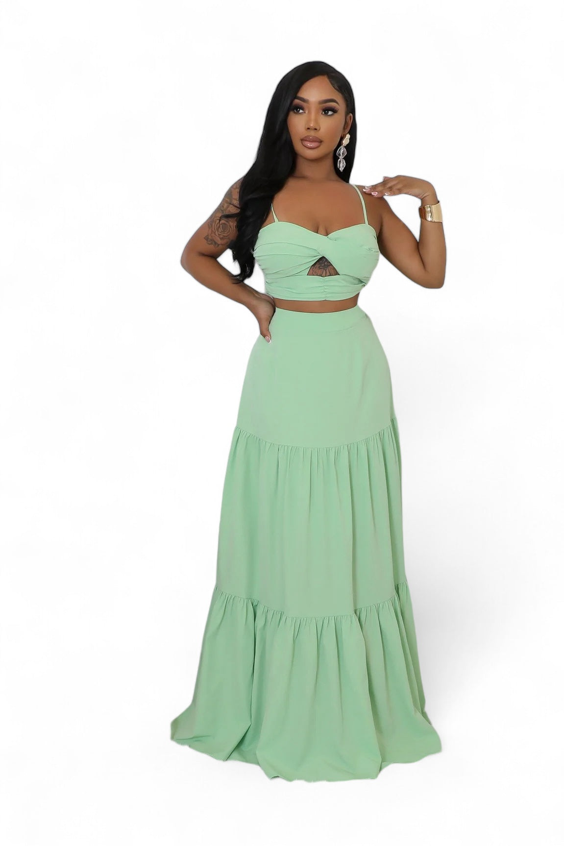 Woman wearing a light green two-piece dress outfit with a white background