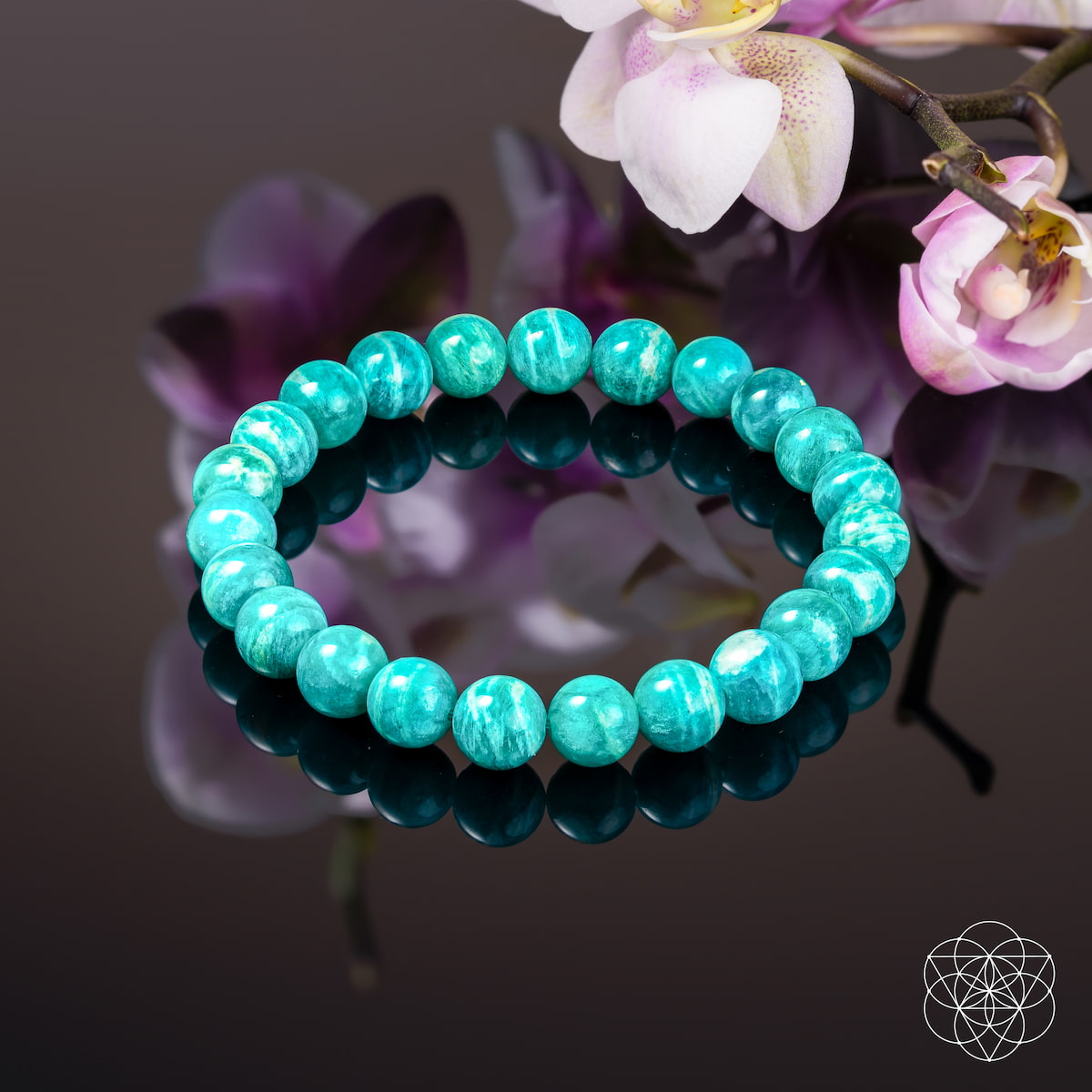 Turquoise beaded bracelet on a reflective surface with flowers in the background Empire of Her Own – Premium Blue Amazonite Bracelet