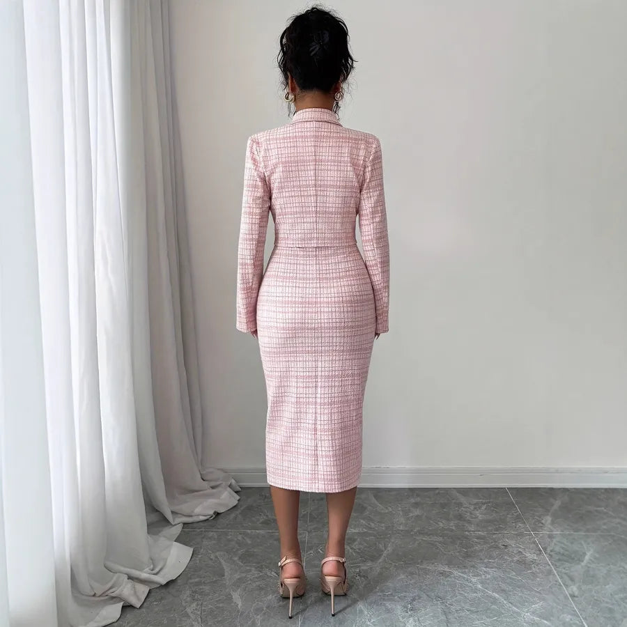 Person wearing a pink plaid twwed checkered suit standing in front of a white curtain. Back View