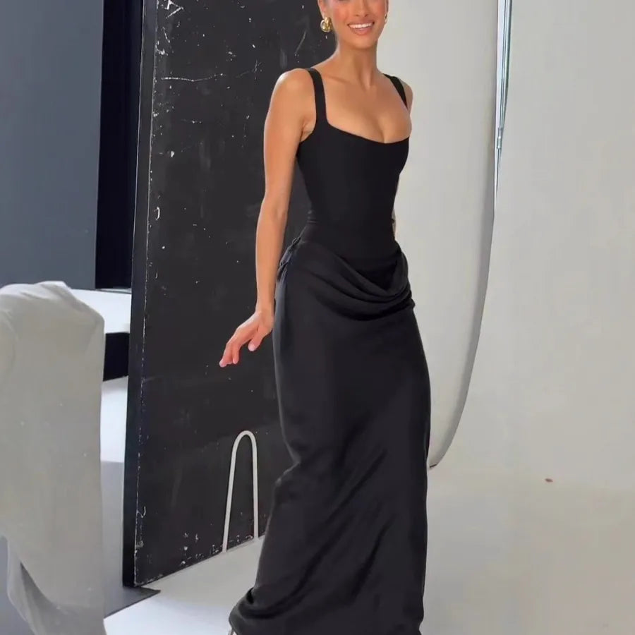 Woman wearing a black dress standing against a neutral background
