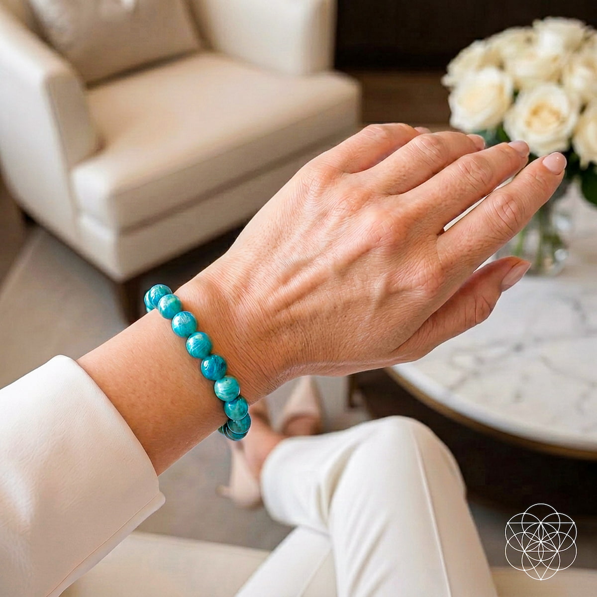 Hand wearing a turquoise beaded bracelet in a living room setting Empire of Her Own – Premium Blue Amazonite Bracelet