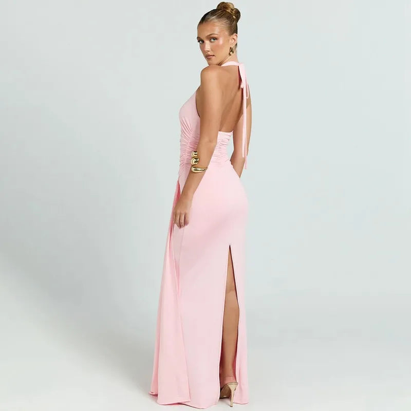 Woman wearing a pink evening gown with a high slit on a light gray background
