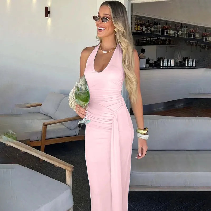 Woman in a pink dress holding a drink in a modern indoor setting