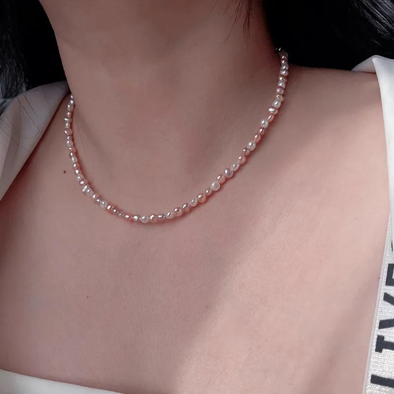 Pearl necklace worn by a person with a neutral background