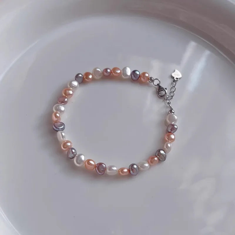 Pearl bracelet with multicolored beads on a white plate