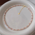 Pearl necklace with a gold clasp on a white plate