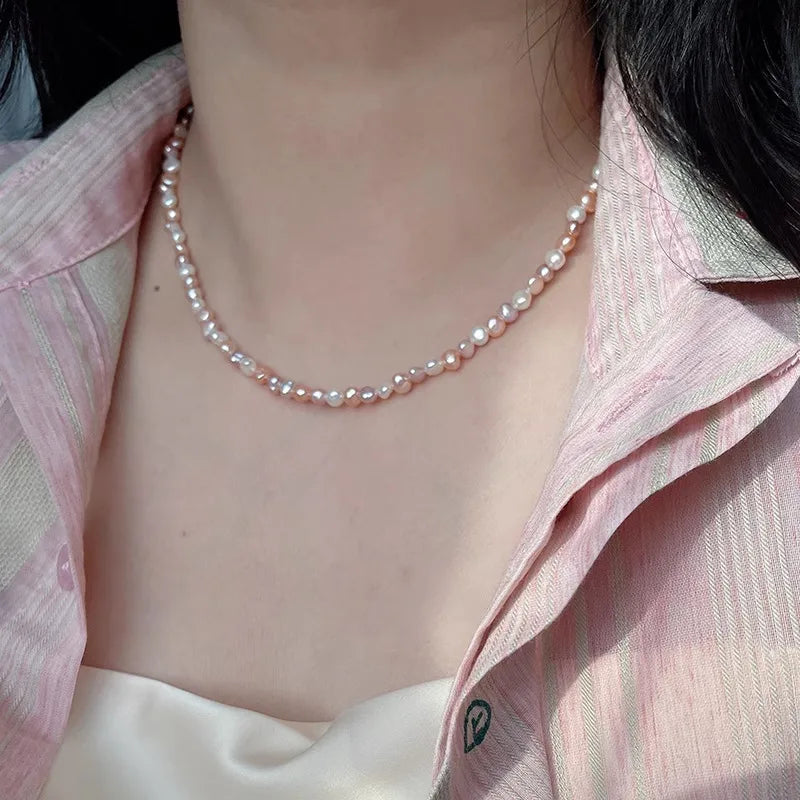 Pearl necklace worn by a person with a pink shirt