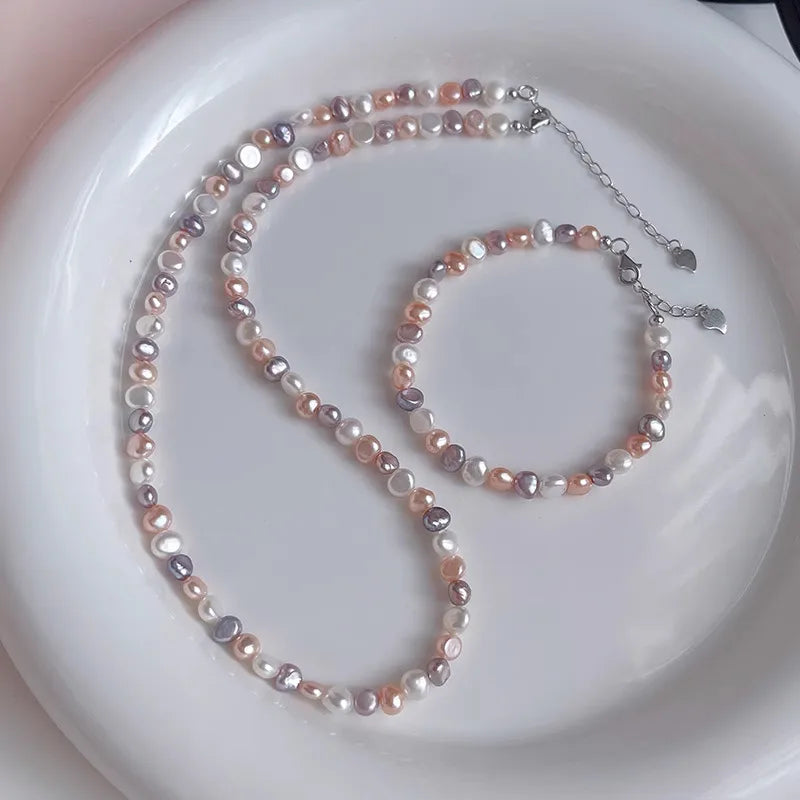 Pearl necklace and bracelet set on a white plate
