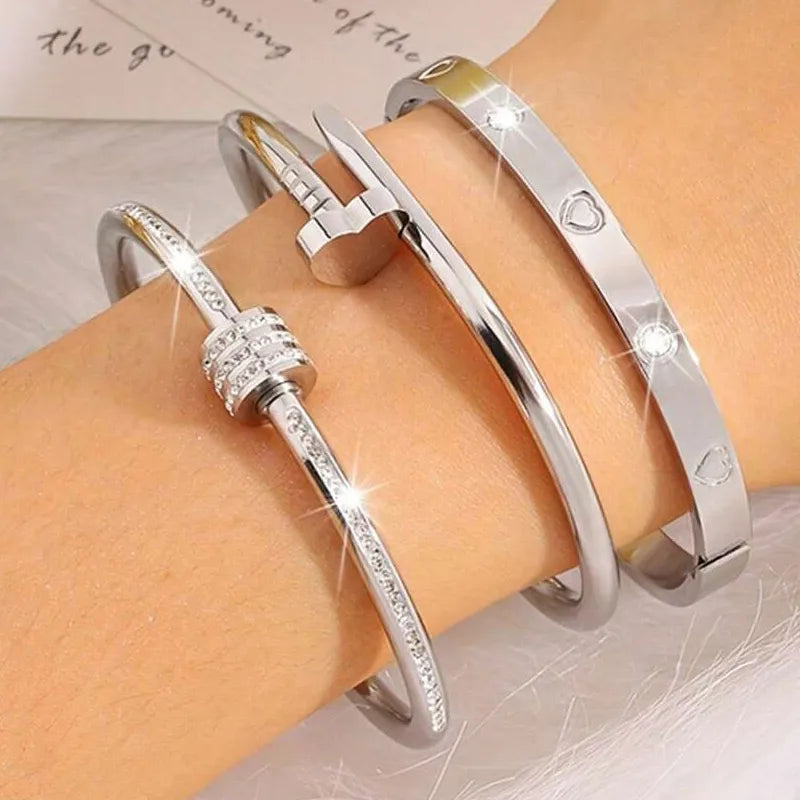 Silver bracelets on a wrist with a soft background 18k gold bracelet,
18k gold plated bracelet,
heart bangle bracelet,
heart bracelet set,
heart jewelry,
love bracelet,
zircon bracelet,
zircon bangle,
stainless steel bracelet,
304 stainless steel jewelry,
waterproof bracelet,
waterproof jewelry,
non tarnish bracelet,
tarnish resistant jewelry,
hypoallergenic bracelet,
gold cuff bracelet,
bangle bracelet set,
stackable bracelets,
bracelet stack,
luxury bracelet,
luxury jewelry,
designer inspired jewelry,
cla