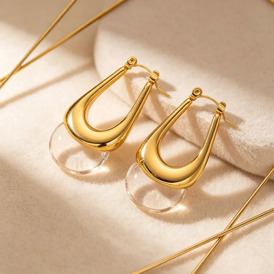 Gold hoop earrings on a beige surface