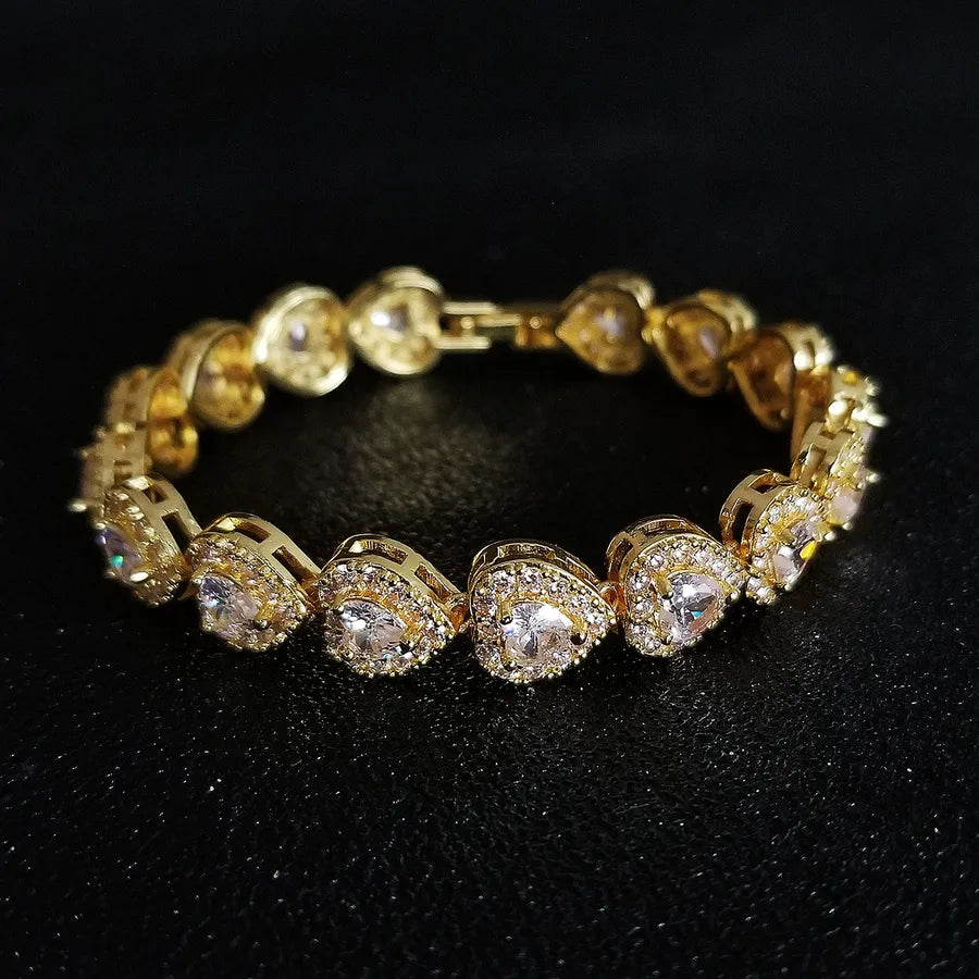 Gold bracelet with heart-shaped gemstones on a black background