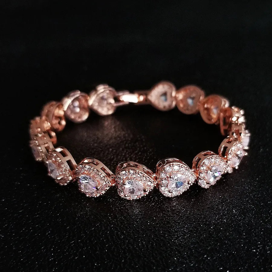 Rose gold bracelet with clear stones on a black background