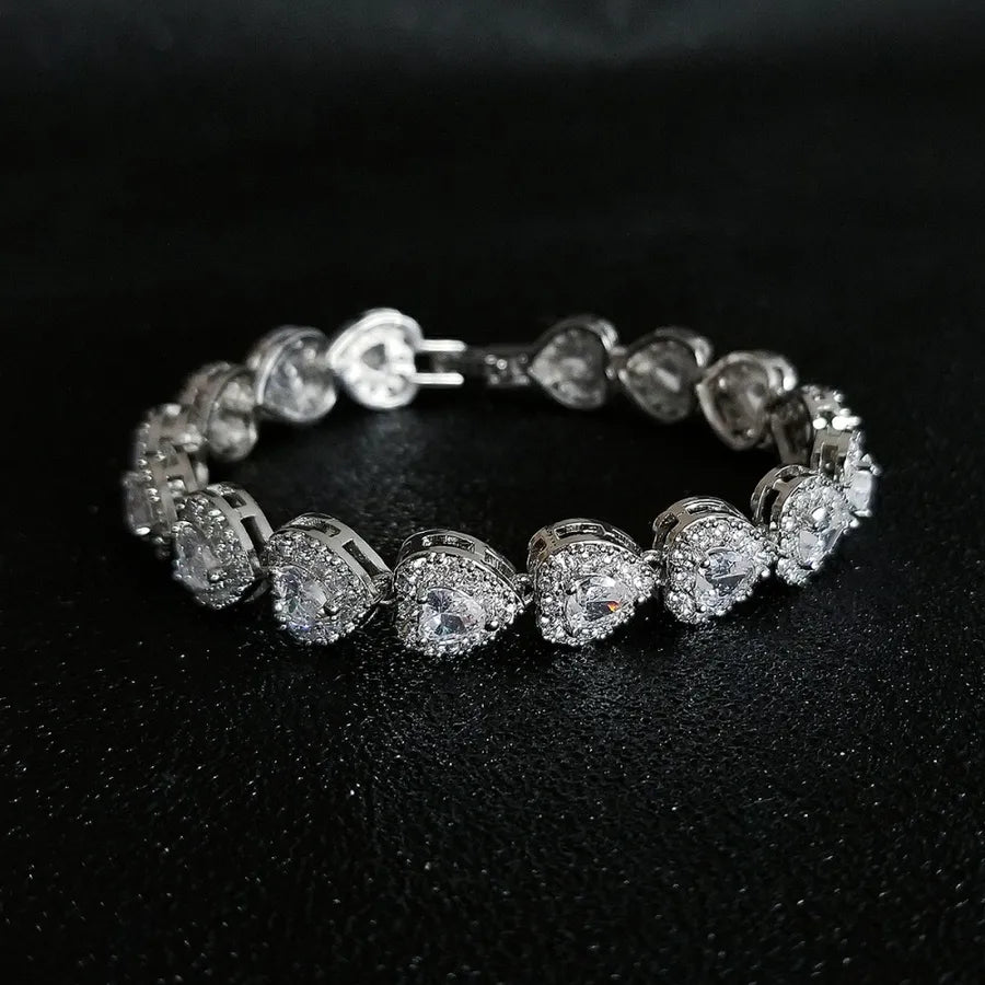 Silver bracelet with heart-shaped gemstones on a black background