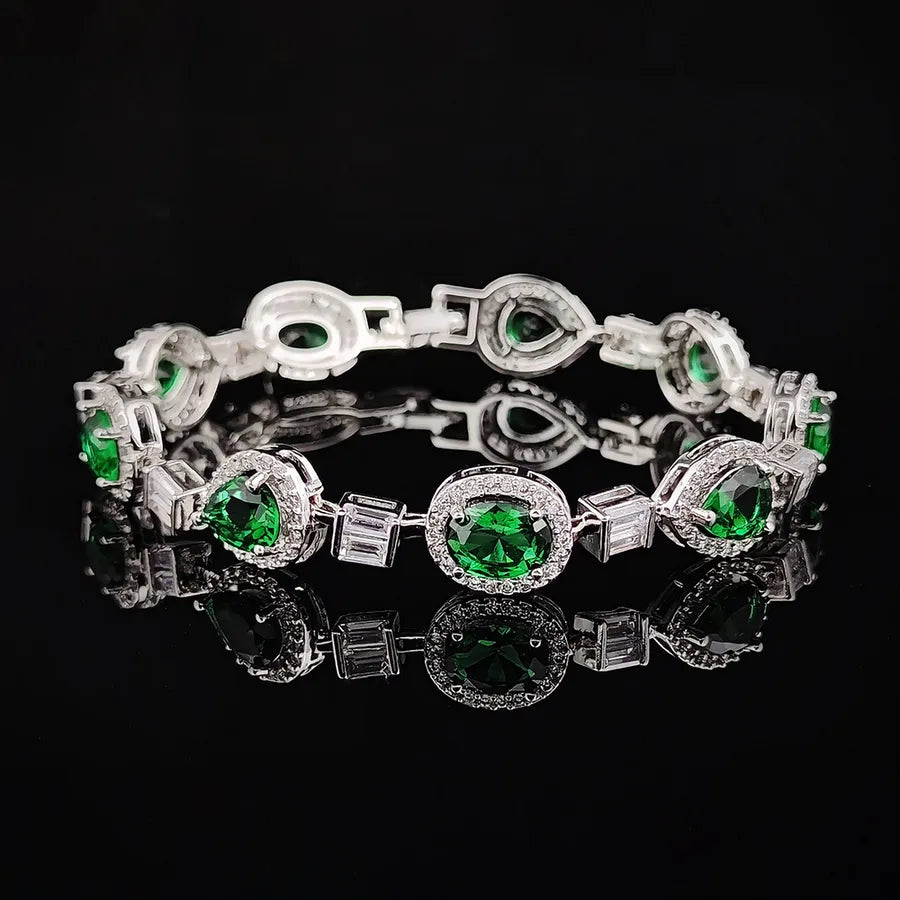 Silver bracelet with green gemstones on a black background