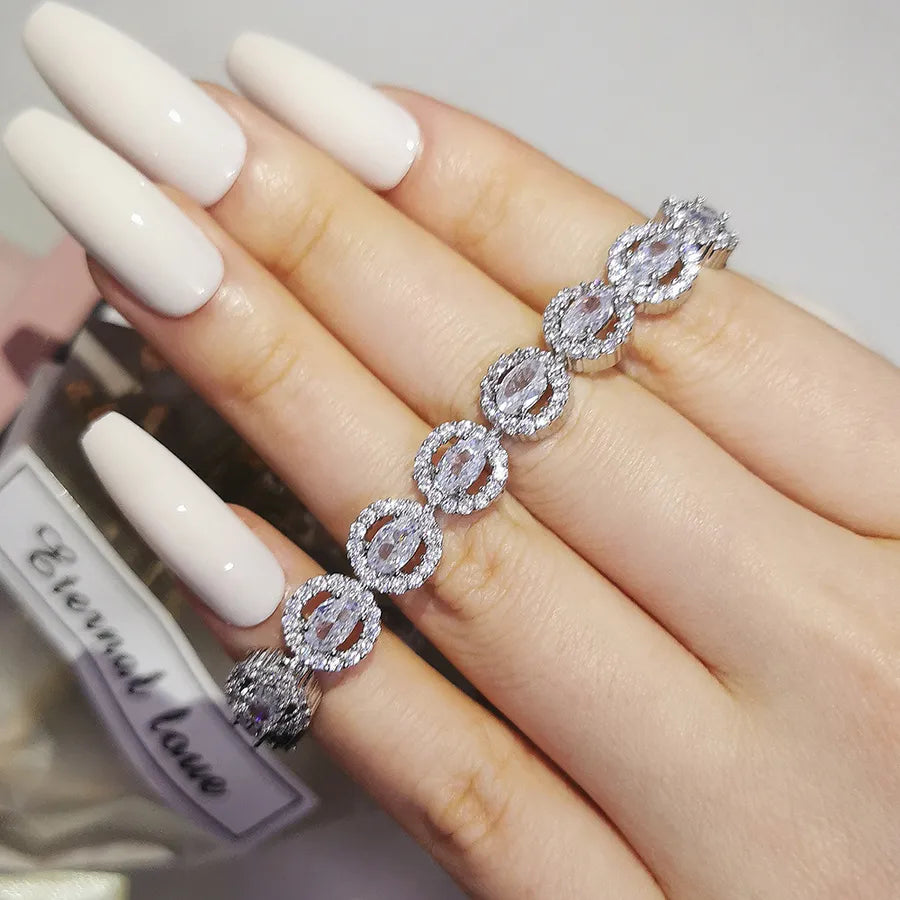 Silver bracelet on a hand with long white nails